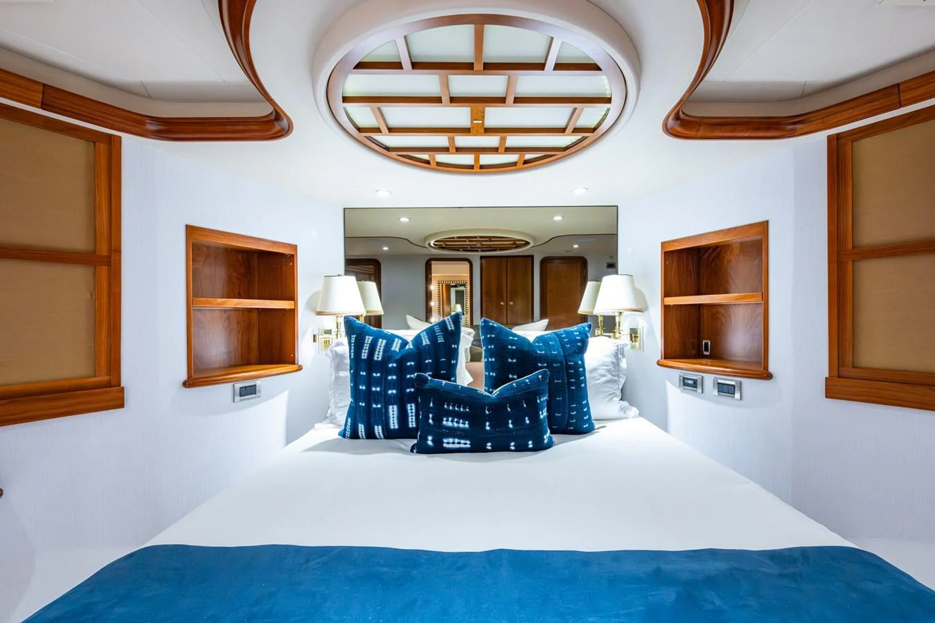 The stateroom features a luxurious bed with elegant blue accents and ample storage space. aboard LILA CUY Yacht for Sale