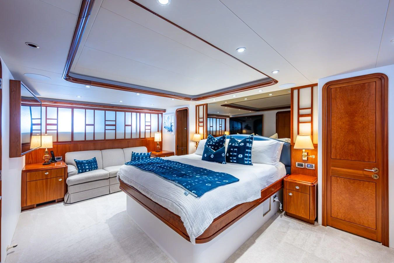 The master stateroom features a luxurious bed, cozy seating area, and elegant wooden accents. aboard LILA CUY Yacht for Sale