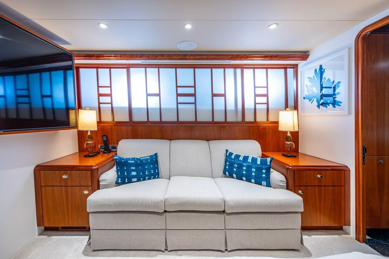 The salon features a comfortable sofa with stylish wooden accents and modern lighting. aboard LILA CUY Yacht for Sale