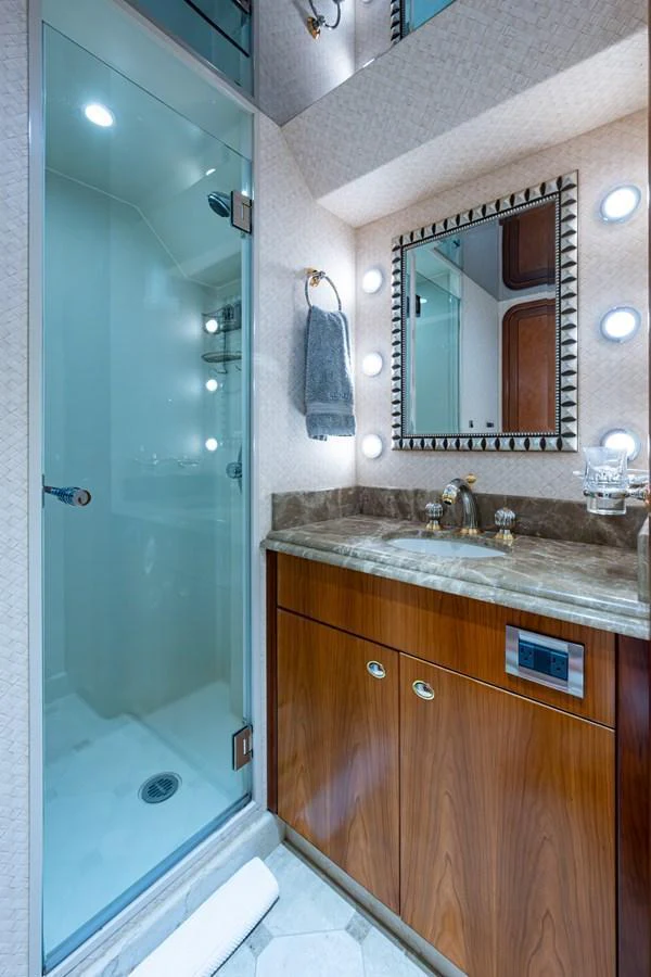 The yacht's bathroom features a sleek glass shower and a stylish vanity with a marble countertop. aboard LILA CUY Yacht for Sale