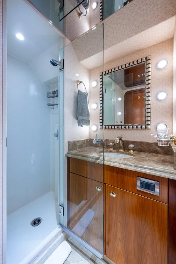 This yacht bathroom features a sleek shower and a stylish vanity with ample lighting. aboard LILA CUY Yacht for Sale