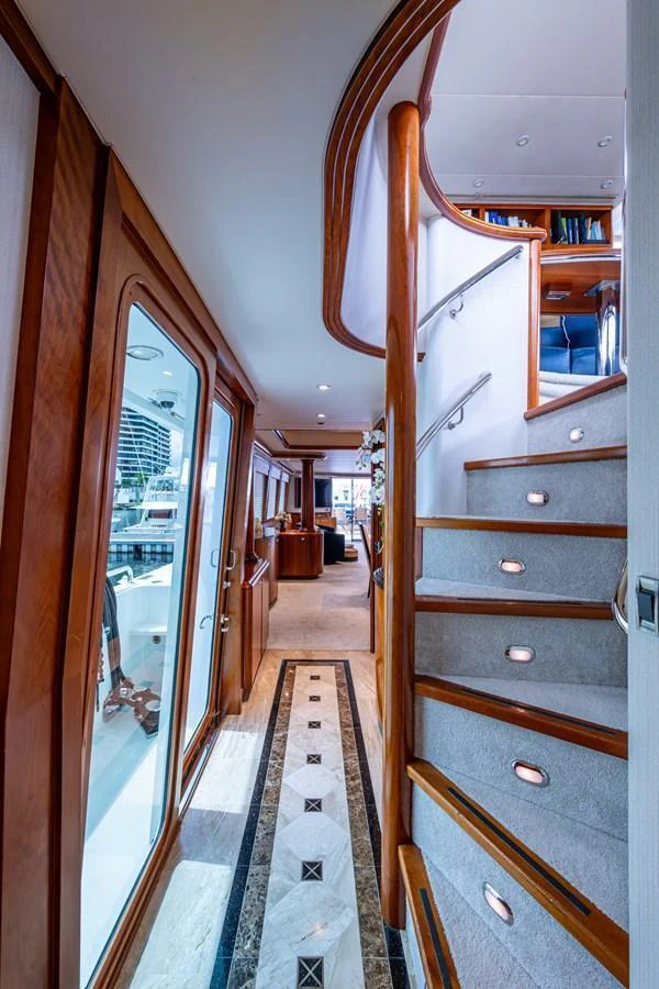 A luxurious yacht interior featuring a beautifully designed staircase with wooden accents and soft lighting. aboard LILA CUY Yacht for Sale