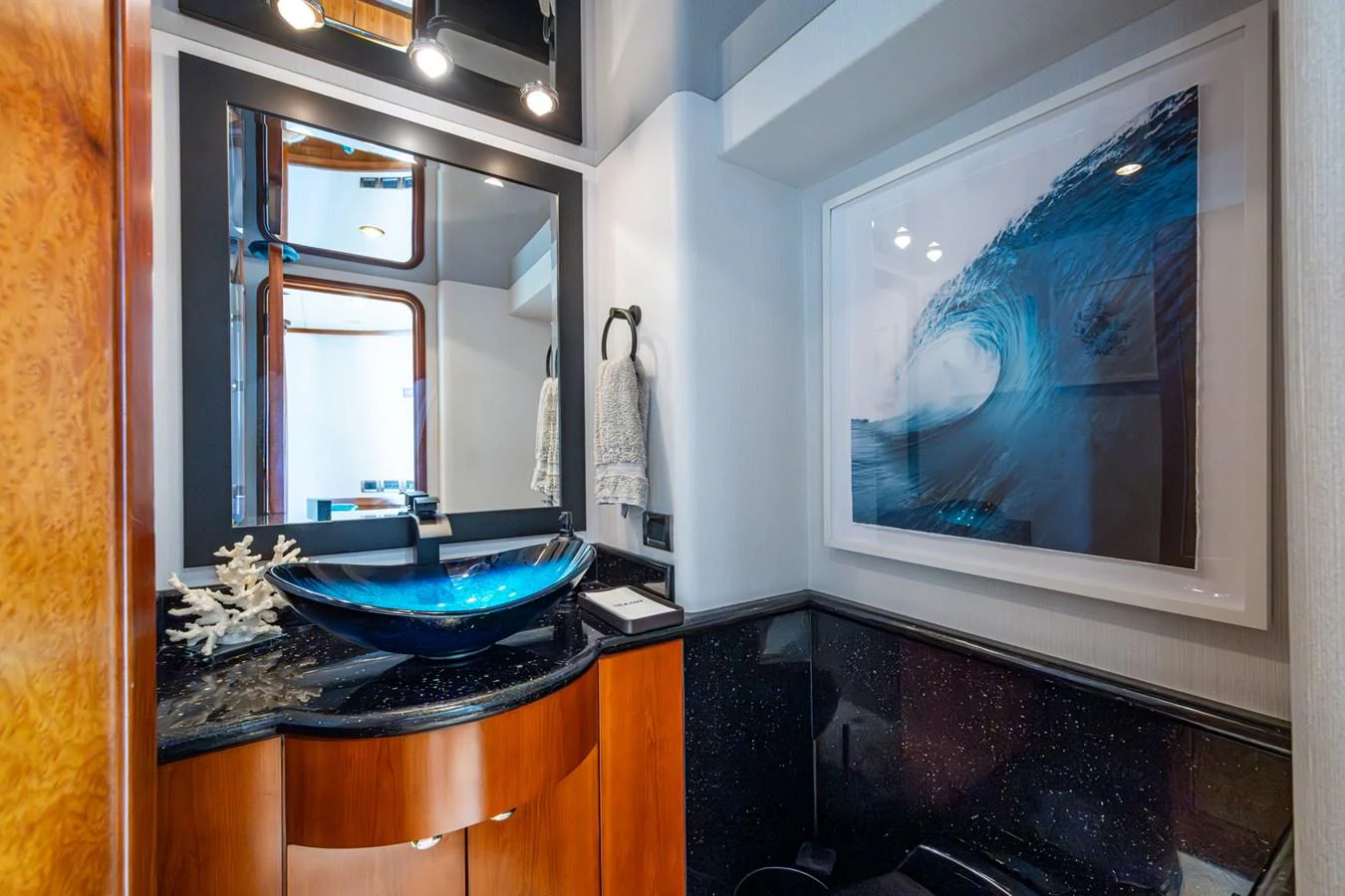 A stylish yacht bathroom featuring a modern glass sink and ocean-themed decor. aboard LILA CUY Yacht for Sale