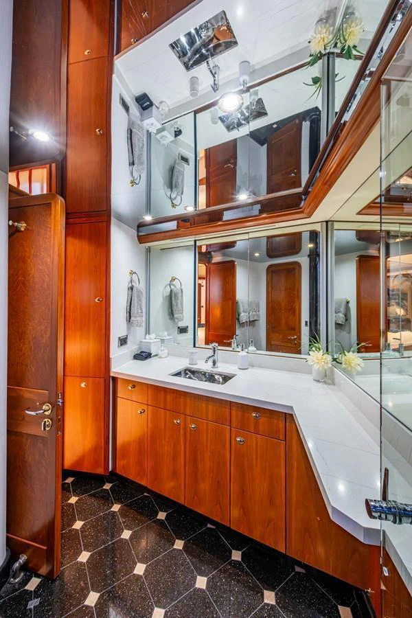 This elegant yacht bathroom features rich wood cabinetry and a sleek, modern design. aboard LILA CUY Yacht for Sale