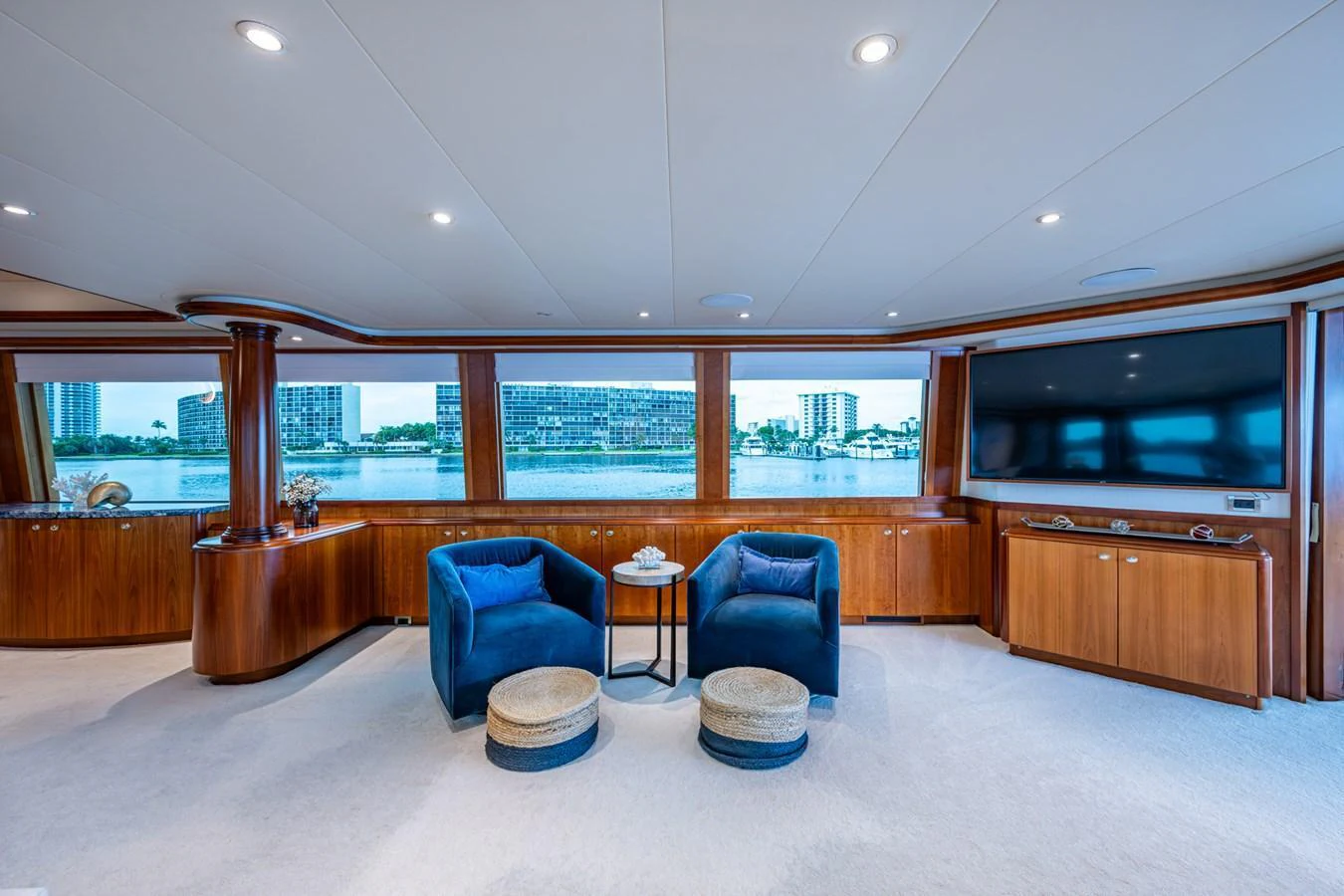 The salon features plush seating with panoramic windows offering stunning water views. aboard LILA CUY Yacht for Sale