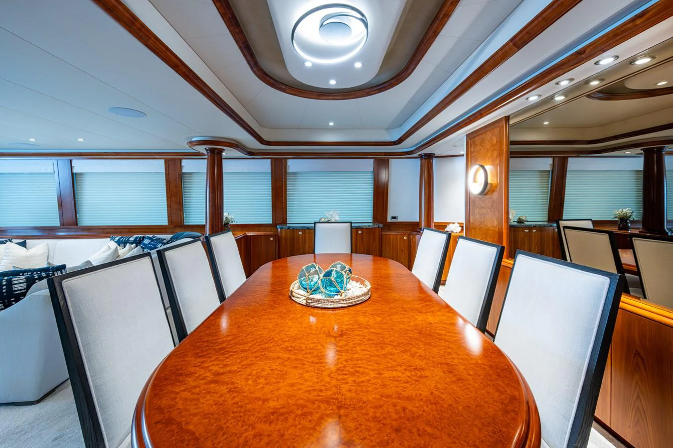 The yacht's dining area features a polished wooden table surrounded by elegant upholstered chairs, creating a sophisticated setting for meals. aboard LILA CUY Yacht for Sale