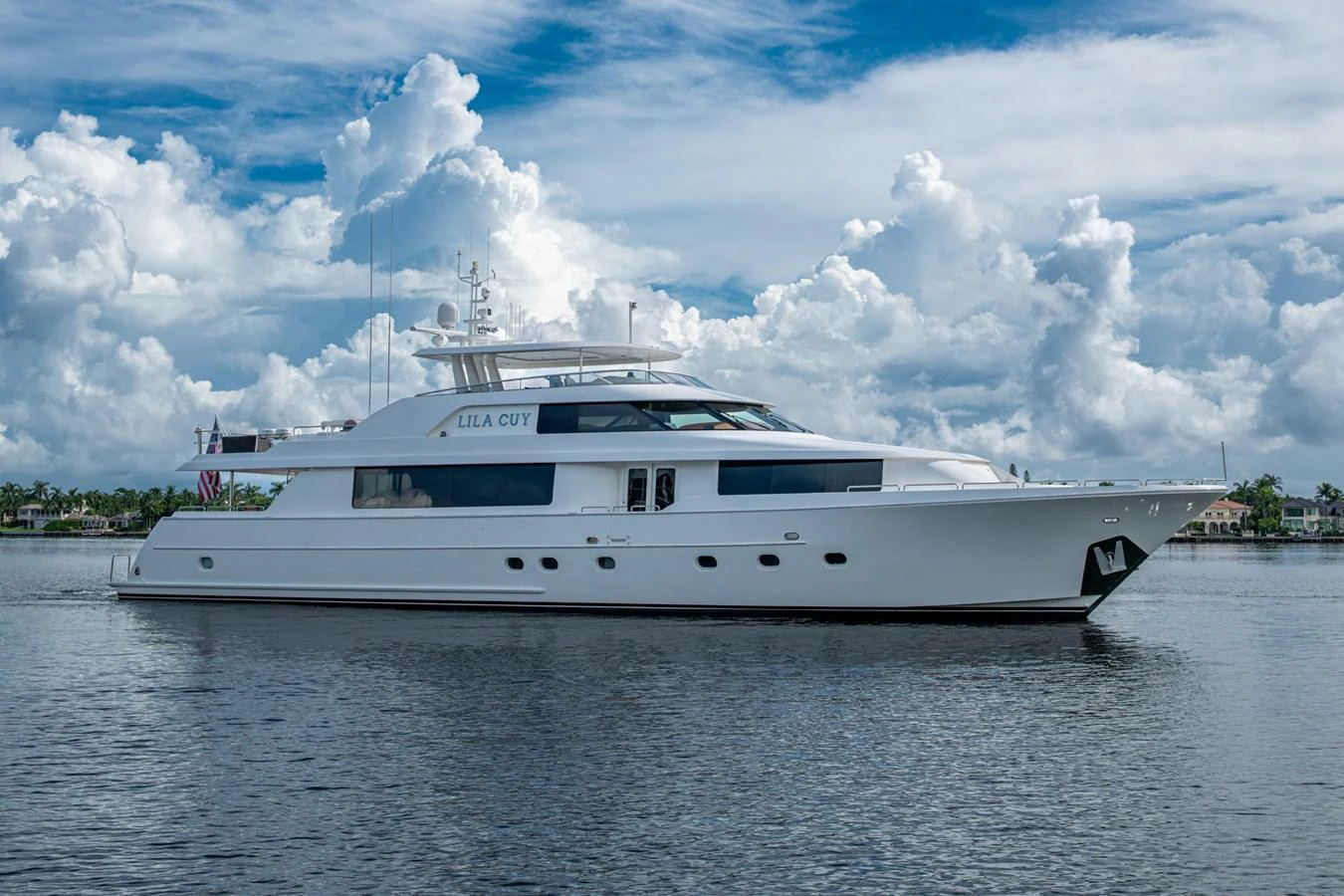 A sleek and elegant yacht cruising on calm waters under a partly cloudy sky. aboard LILA CUY Yacht for Sale