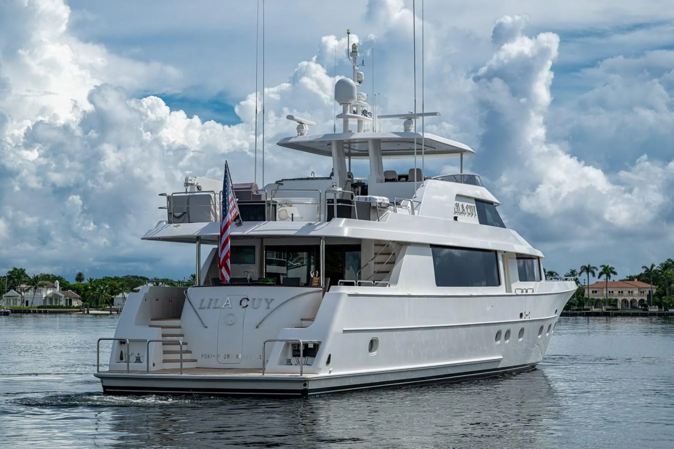 A sleek and elegant yacht cruises on calm waters under a partly cloudy sky. aboard LILA CUY Yacht for Sale