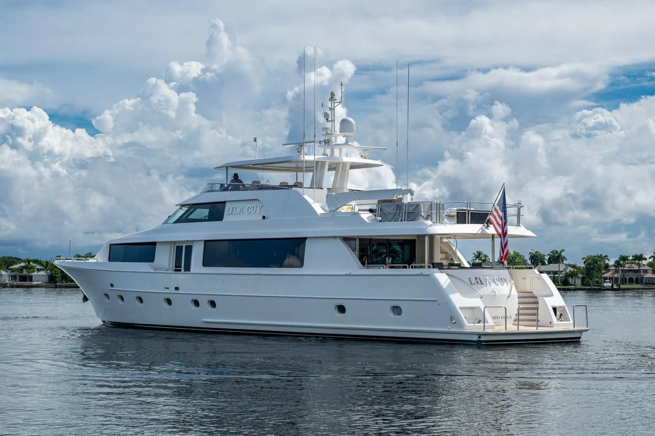A luxurious yacht is anchored on calm waters under a partly cloudy sky. aboard LILA CUY Yacht for Sale