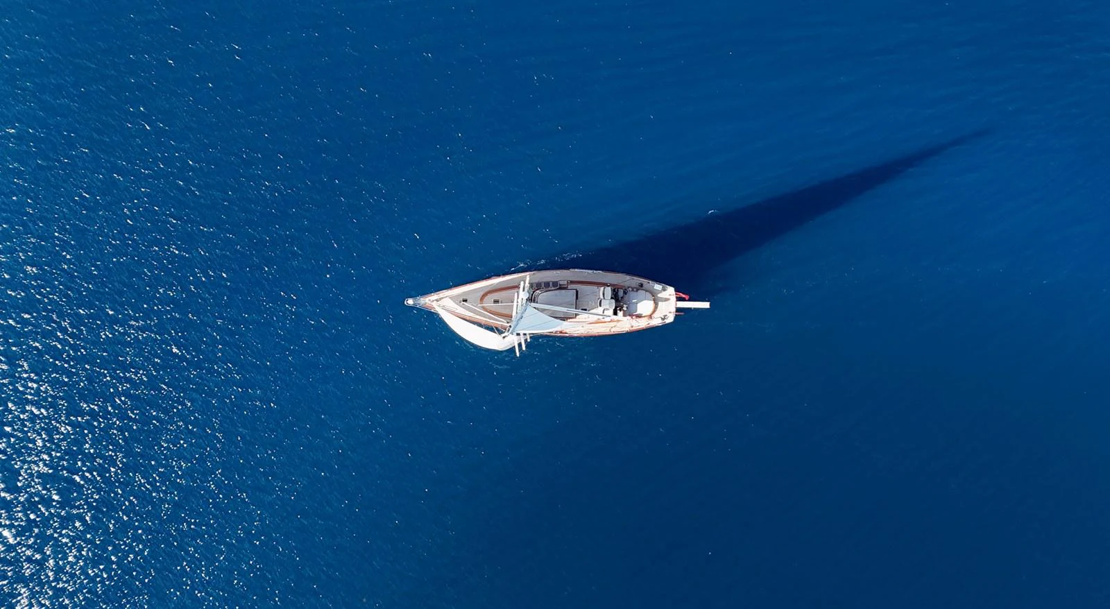 A stunning aerial view of a sleek yacht cruising on deep blue waters. aboard PORTOBELLO Yacht for Sale