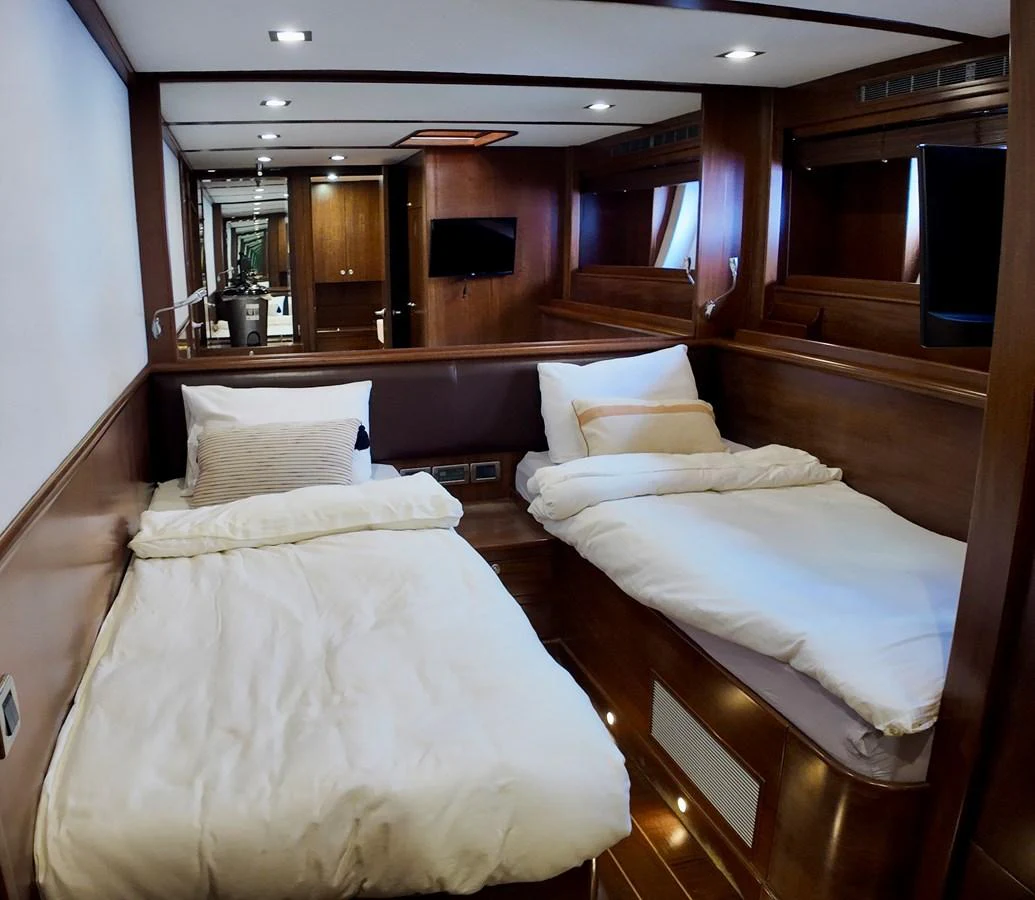 A cozy guest cabin with twin beds and warm wooden finishes. aboard PORTOBELLO Yacht for Sale