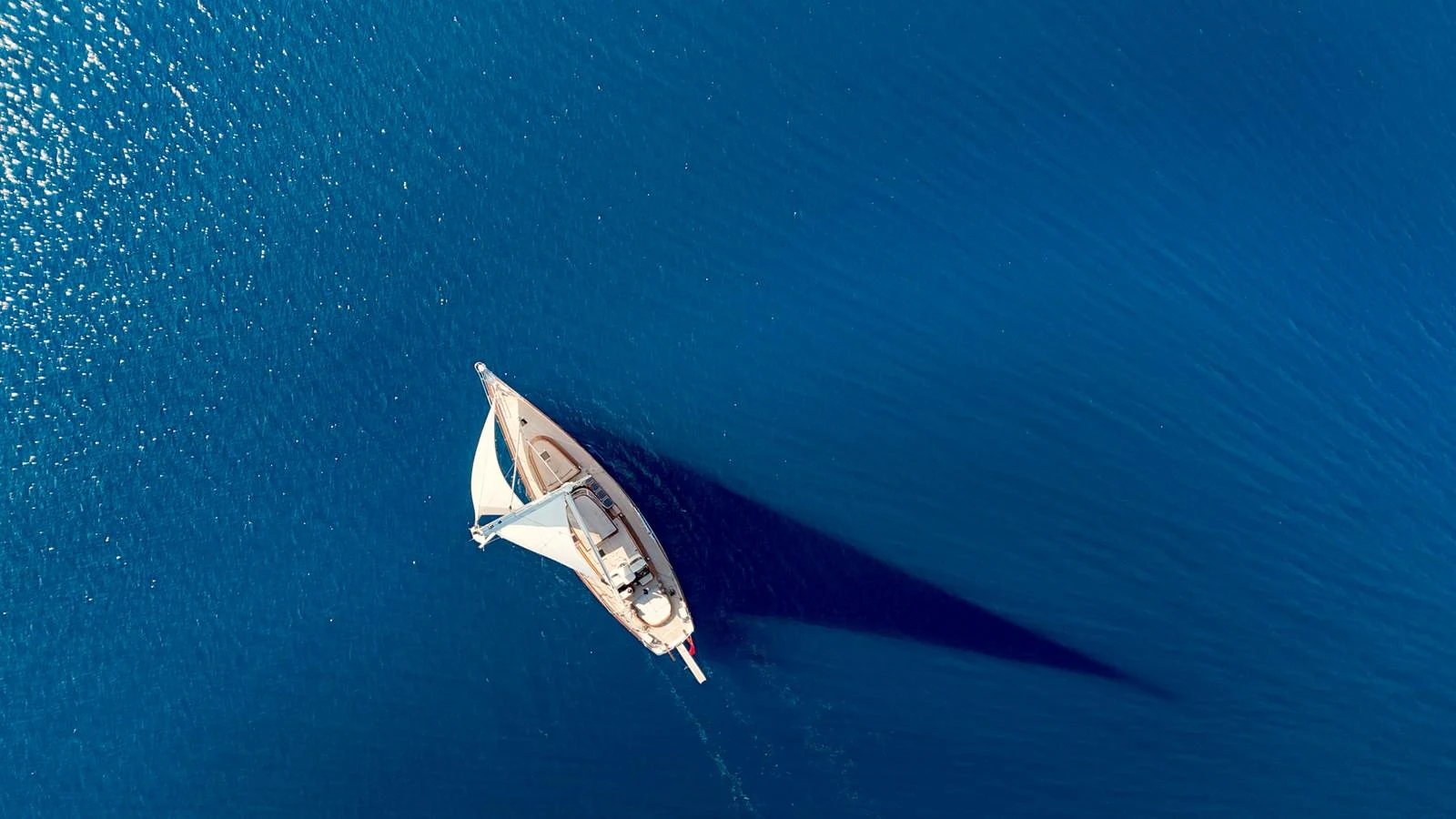 A stunning aerial view of a yacht sailing on calm, deep blue waters. aboard PORTOBELLO Yacht for Sale