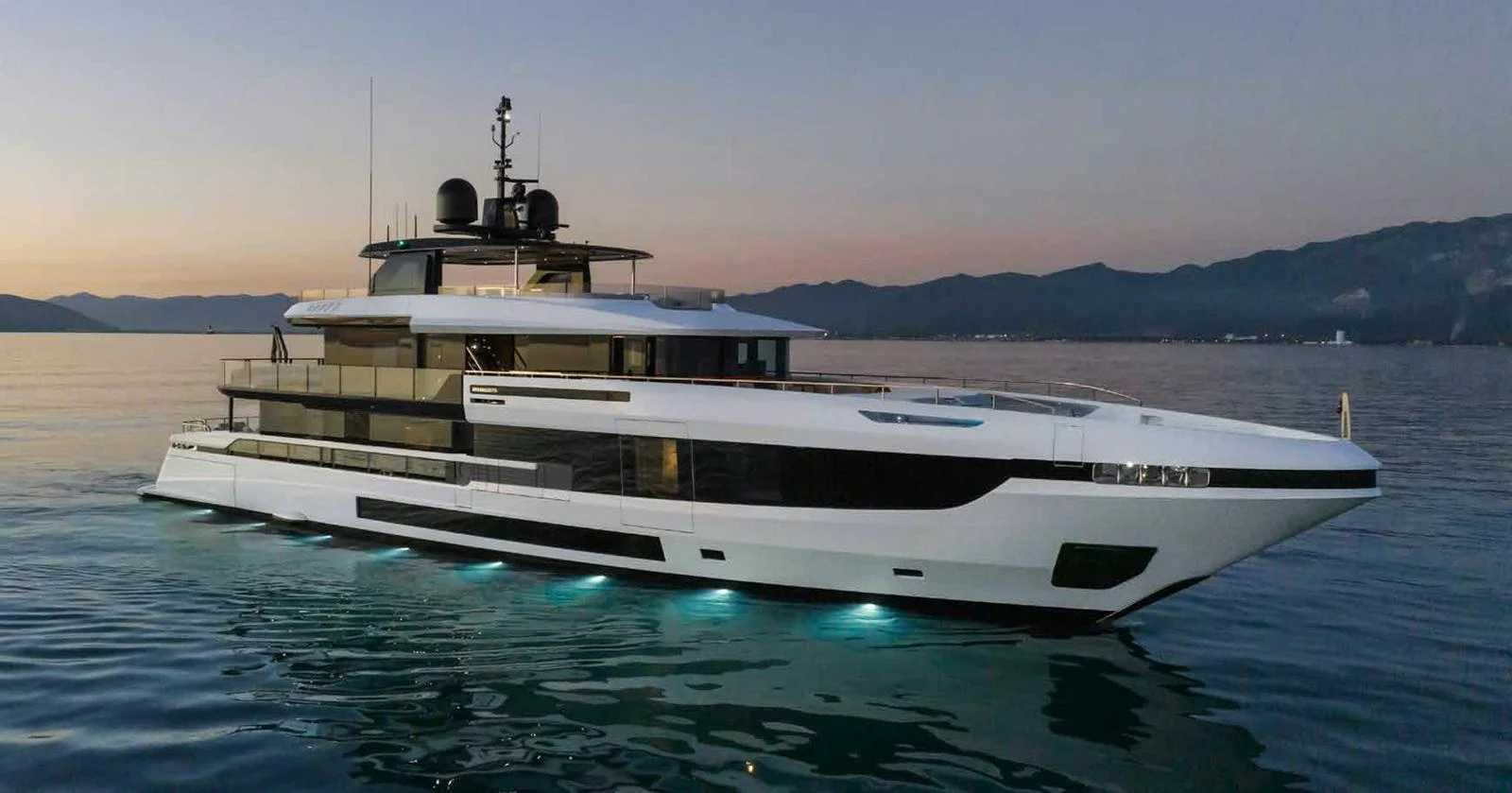 A sleek and modern yacht glides through calm waters at dusk. aboard MANGUSTA OCEANO 44, #8 Yacht for Sale