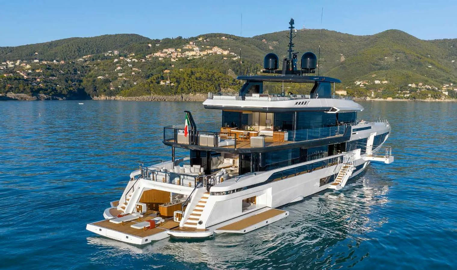 A luxurious yacht cruising on calm waters with a scenic hillside backdrop. aboard MANGUSTA OCEANO 44, #8 Yacht for Sale