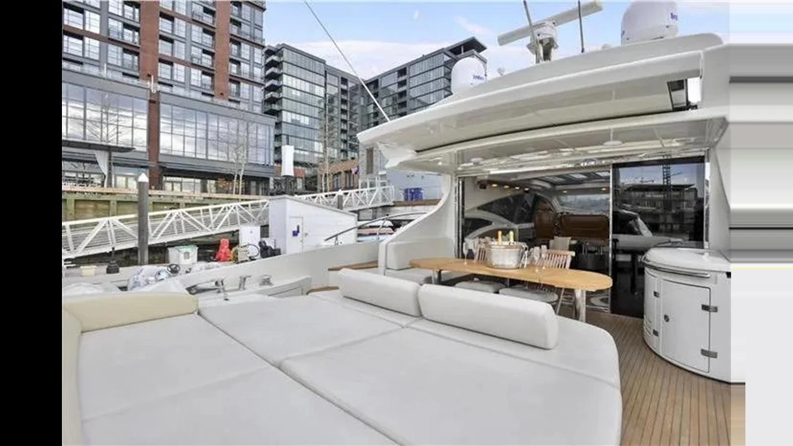 The aft deck features a spacious lounging area with plush seating and an elegant dining table, perfect for alfresco dining and relaxation. aboard 2007 AZIMUT 68S Yacht for Sale