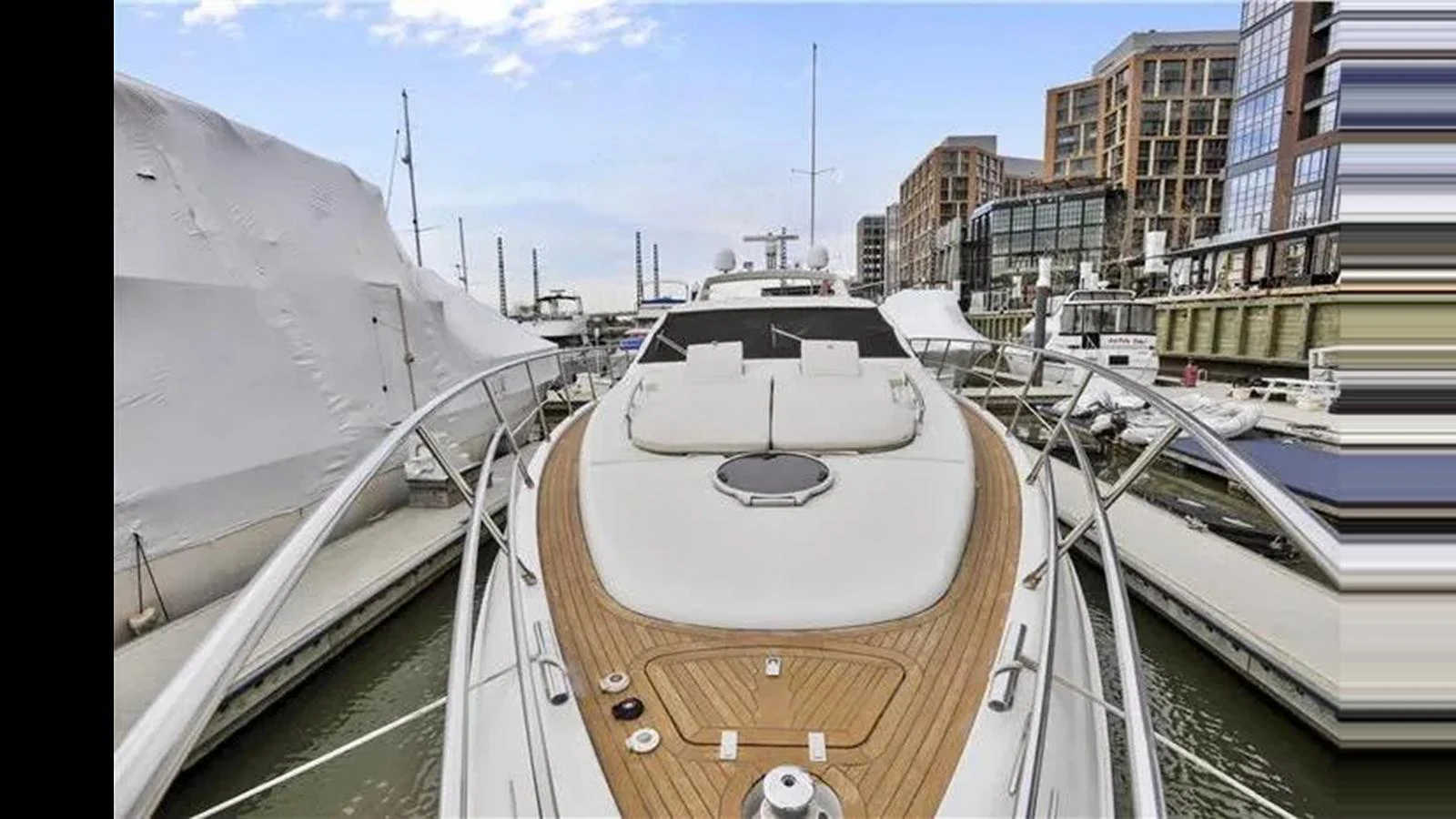The yacht is docked in a marina, showcasing its sleek bow and spacious deck. aboard 2007 AZIMUT 68S Yacht for Sale