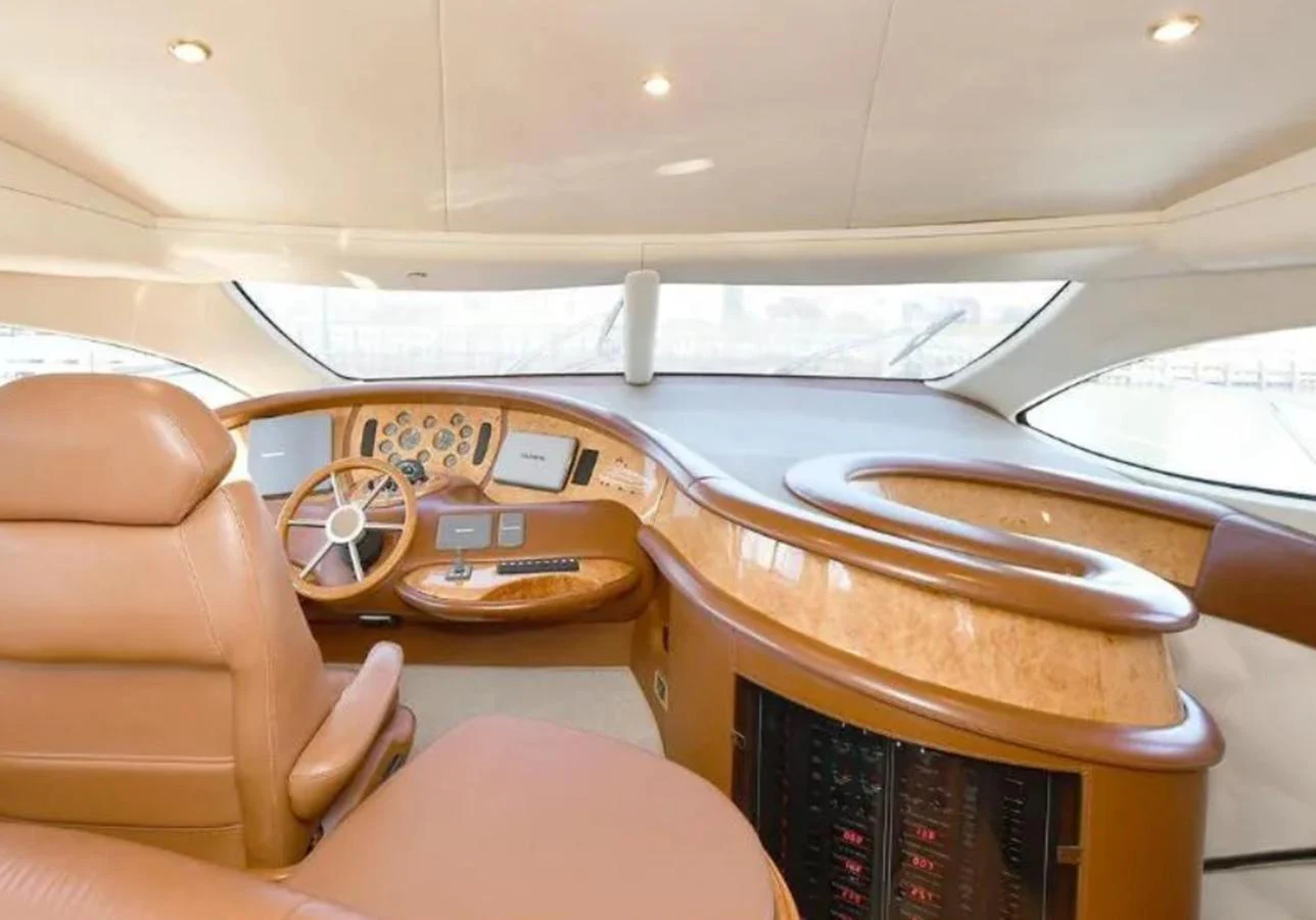 The helm station features luxurious leather seating and a sophisticated control panel with a panoramic view. aboard 2005 AZIMUT 68E Yacht for Sale