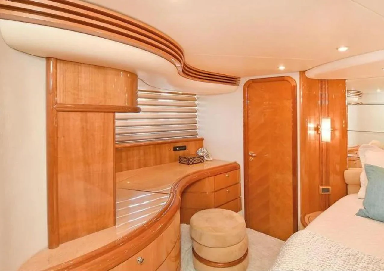 The stateroom features elegant wood finishes and a cozy seating area, creating a warm and inviting atmosphere. aboard 2005 AZIMUT 68E Yacht for Sale