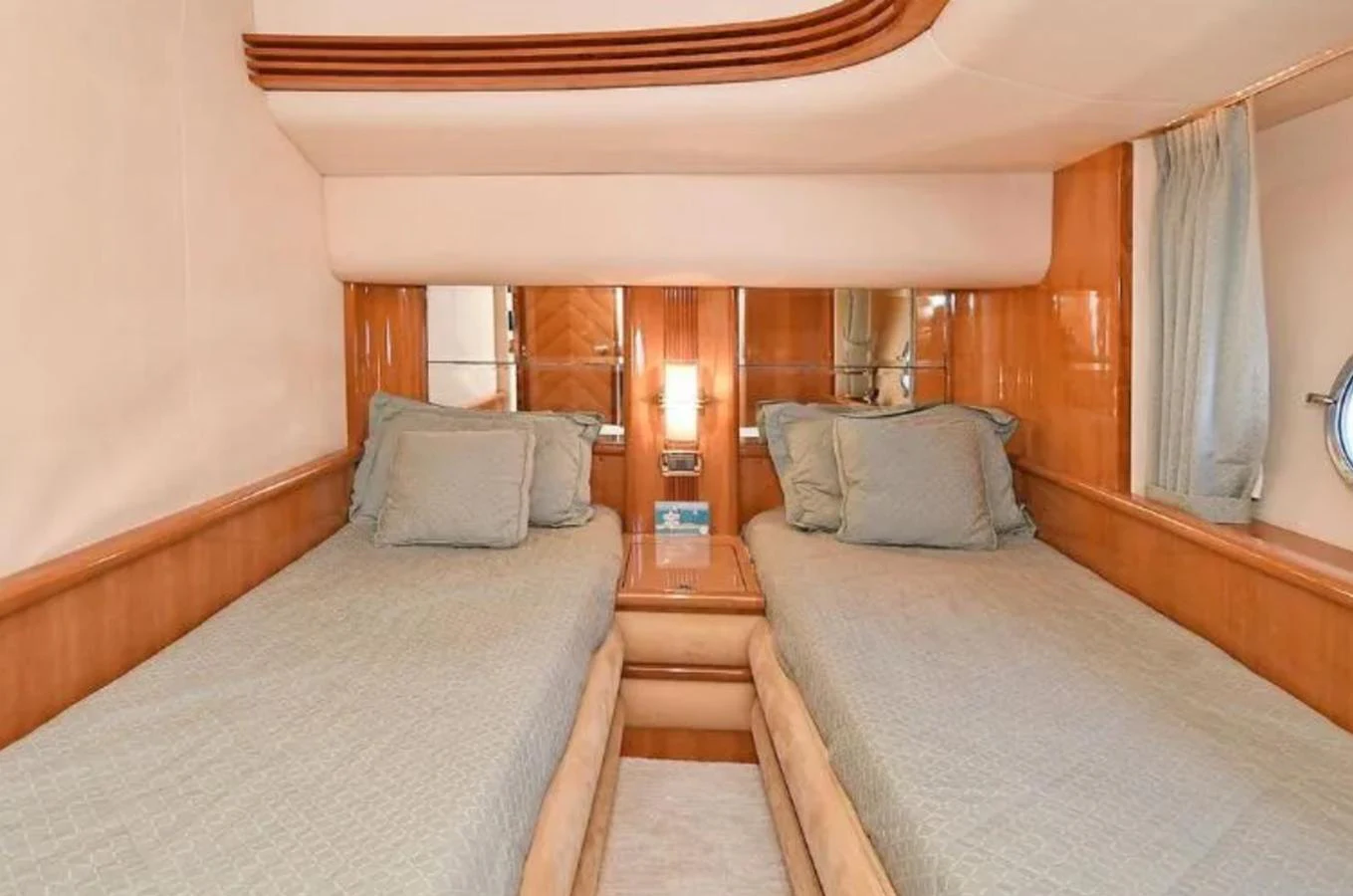 A cozy twin stateroom with elegant wood paneling and comfortable bedding. aboard 2005 AZIMUT 68E Yacht for Sale