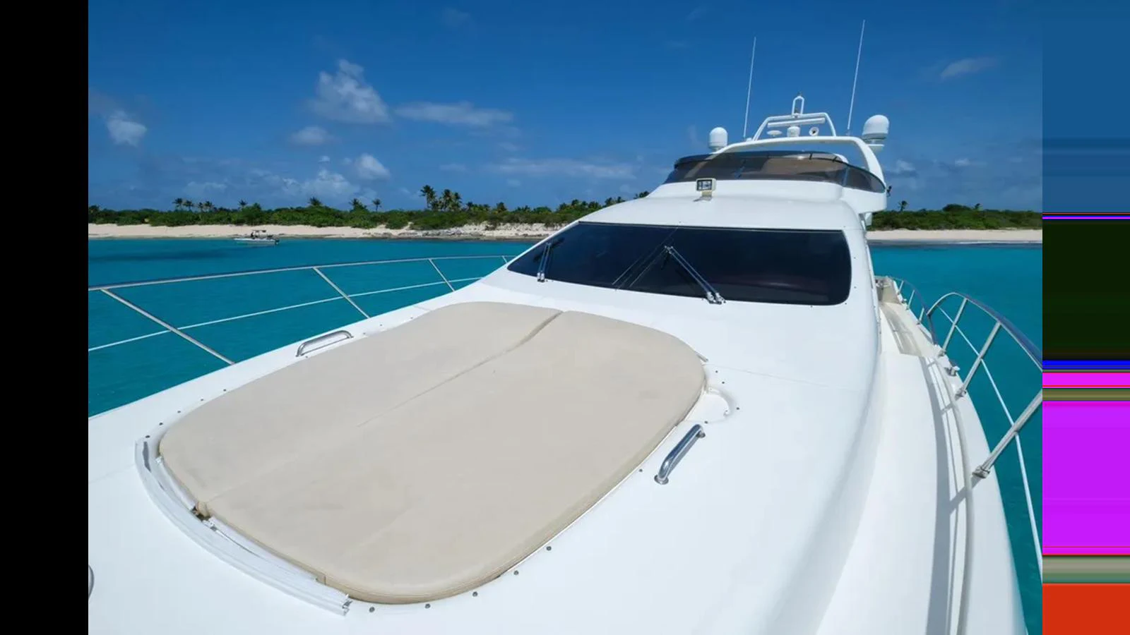 The yacht's foredeck features a spacious sunpad under a clear blue sky, perfect for relaxation. aboard 2005 AZIMUT 68E Yacht for Sale