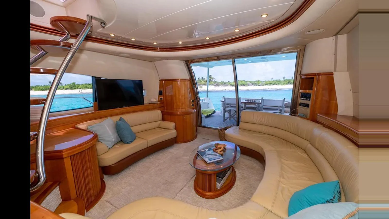 The yacht's salon features plush seating, a flat-screen TV, and large windows offering stunning ocean views. aboard 2005 AZIMUT 68E Yacht for Sale