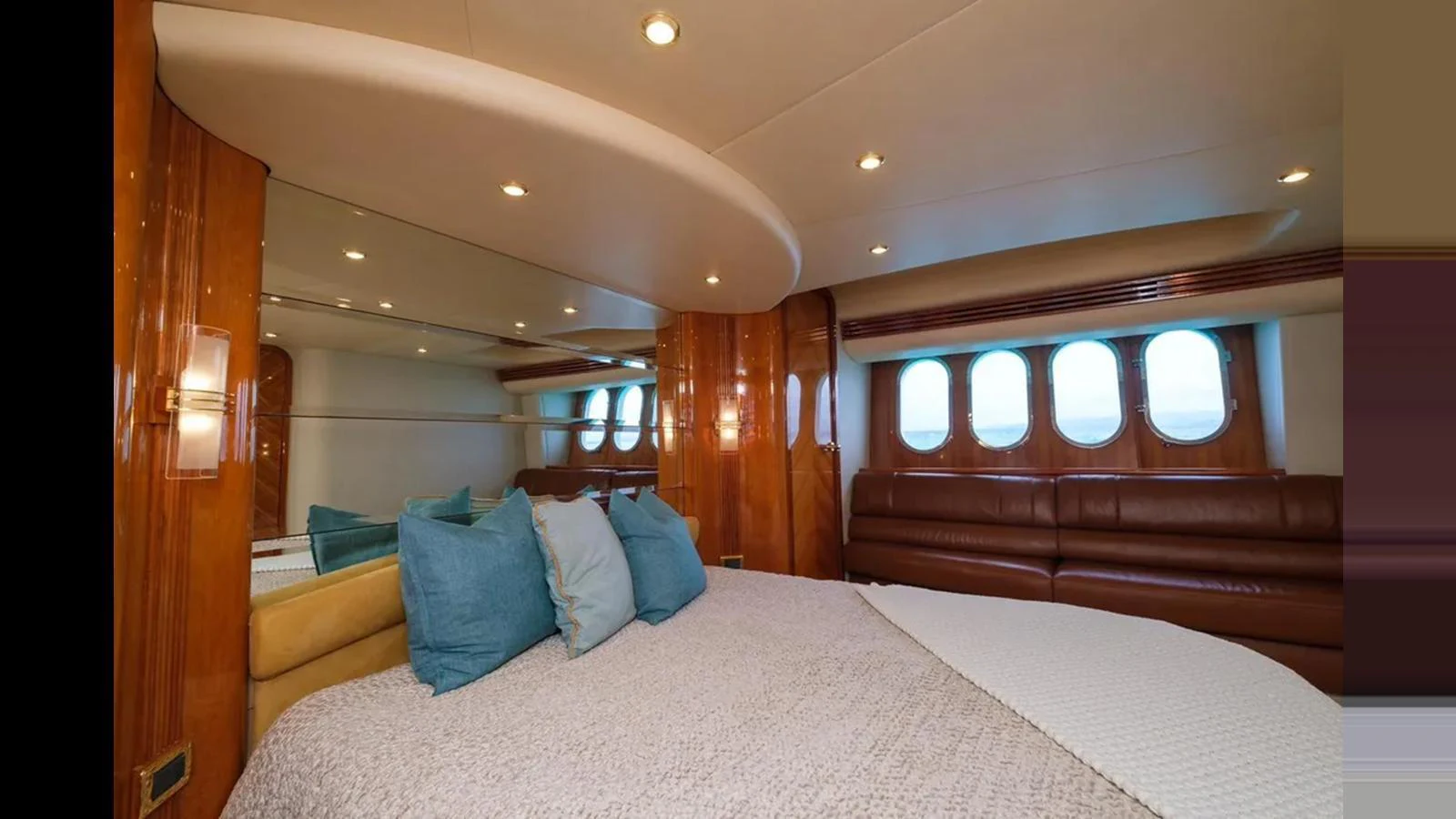 The stateroom features a luxurious bed with plush pillows and ample natural light from the windows. aboard 2005 AZIMUT 68E Yacht for Sale