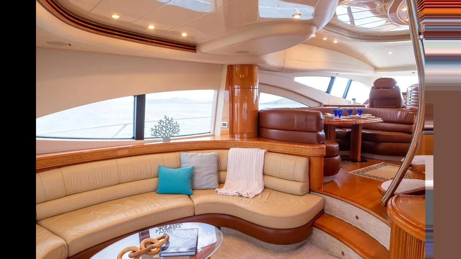 The yacht's salon features a luxurious seating area with plush cushions and elegant wood finishes. aboard 2005 AZIMUT 68E Yacht for Sale
