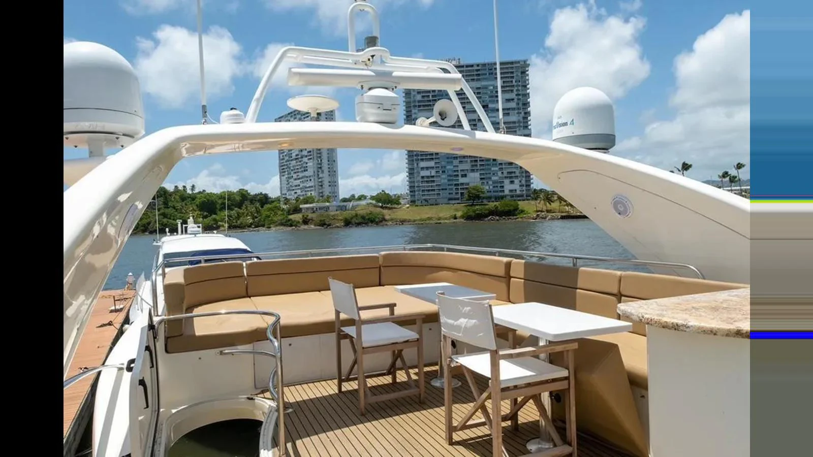 The aft deck features a comfortable seating area with a table, perfect for outdoor dining and relaxation. aboard 2005 AZIMUT 68E Yacht for Sale