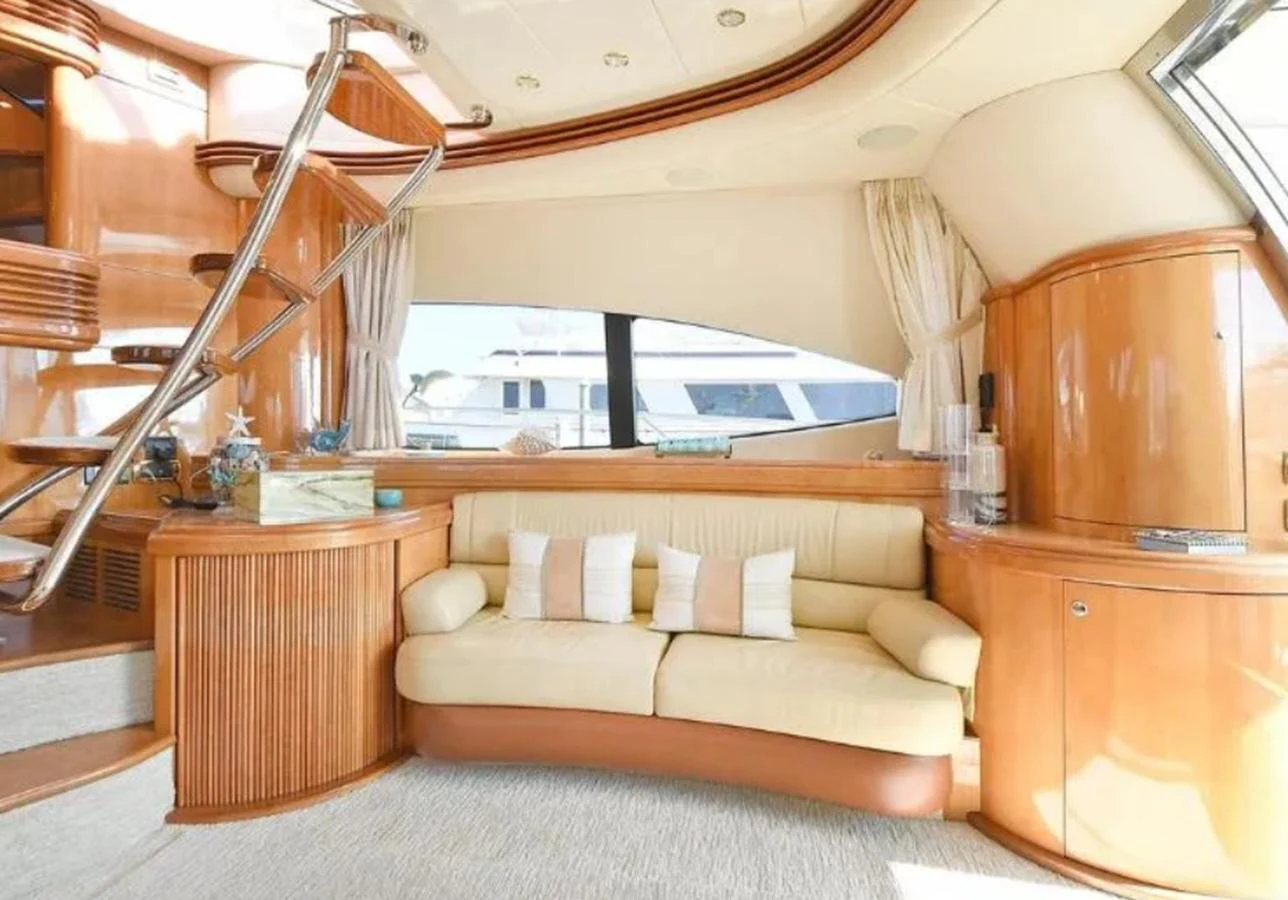 The yacht's salon features a cozy seating area with elegant wood finishes and large windows for natural light. aboard 2005 AZIMUT 68E Yacht for Sale