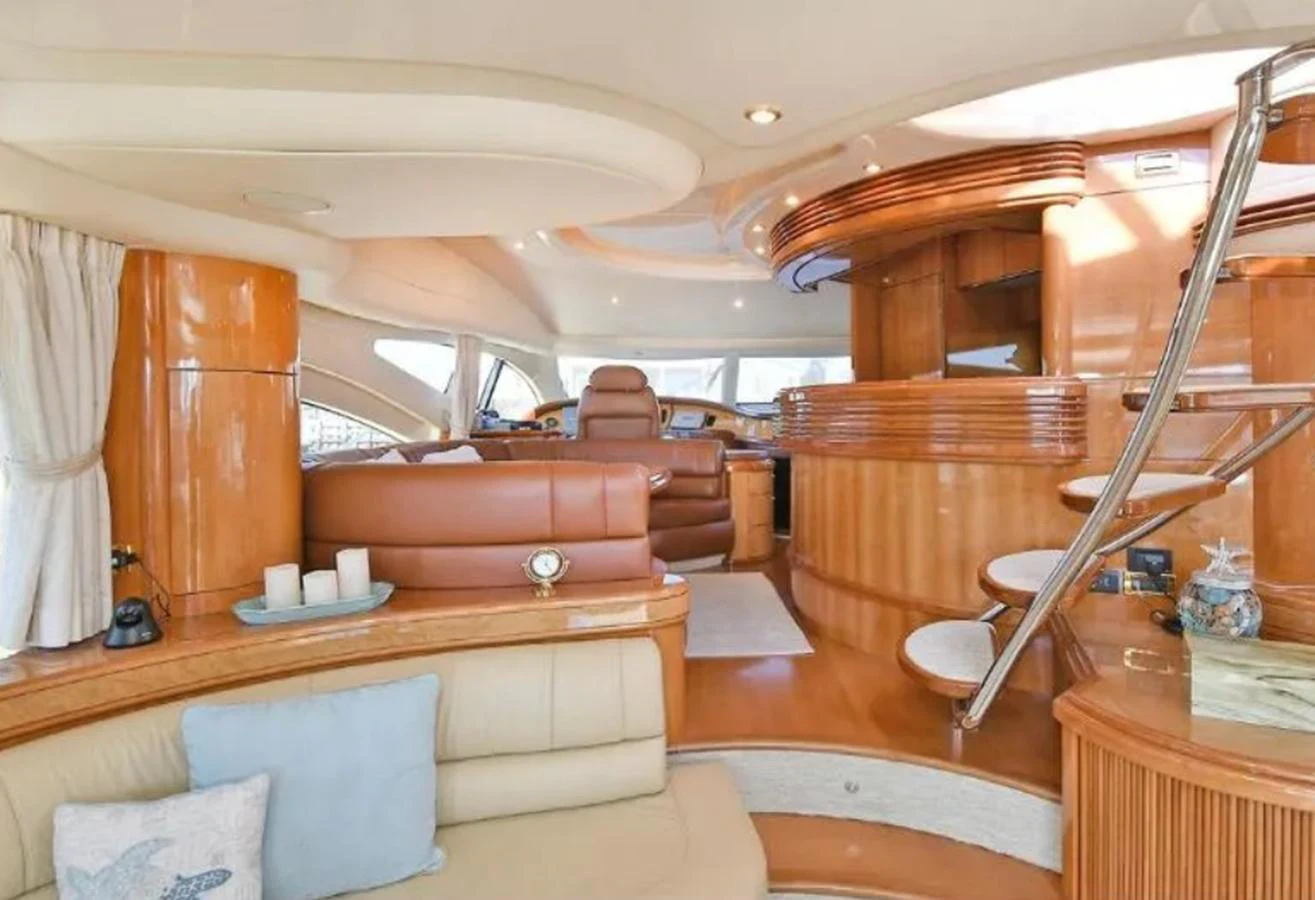 The yacht's salon features luxurious seating and elegant wooden finishes, creating a warm and inviting atmosphere. aboard 2005 AZIMUT 68E Yacht for Sale