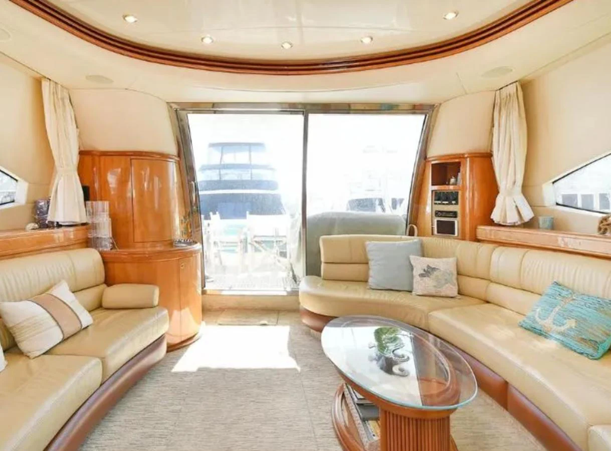 The yacht's salon features plush seating, elegant wood finishes, and ample natural light. aboard 2005 AZIMUT 68E Yacht for Sale