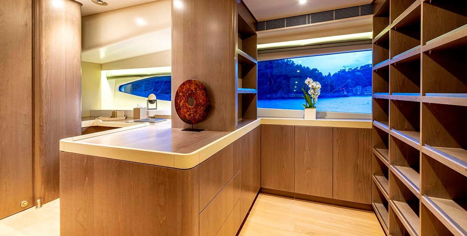 A spacious and elegantly designed interior with ample storage and a large window offering scenic views. aboard UNEXPECTED Yacht for Sale
