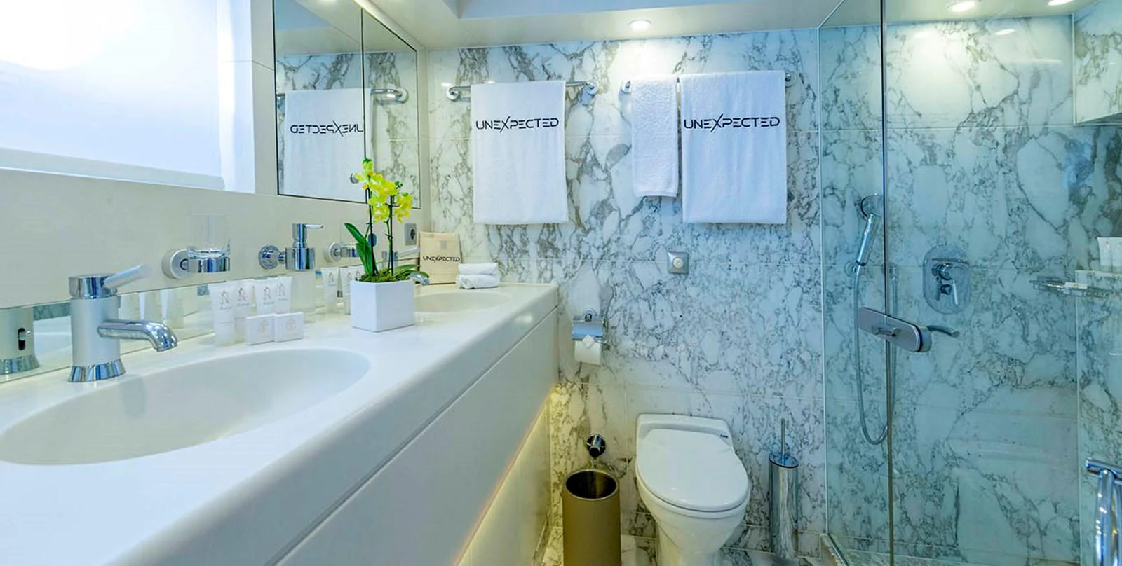A luxurious yacht bathroom featuring marble walls and modern fixtures. aboard UNEXPECTED Yacht for Sale