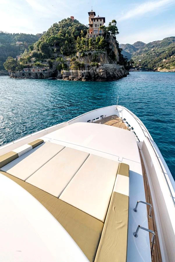 The yacht's bow offers a luxurious sunbathing area with stunning coastal views. aboard UNEXPECTED Yacht for Sale