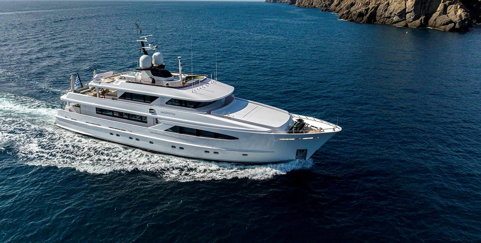 A luxurious yacht cruises through the open sea, showcasing its sleek design and spacious decks. aboard UNEXPECTED Yacht for Sale