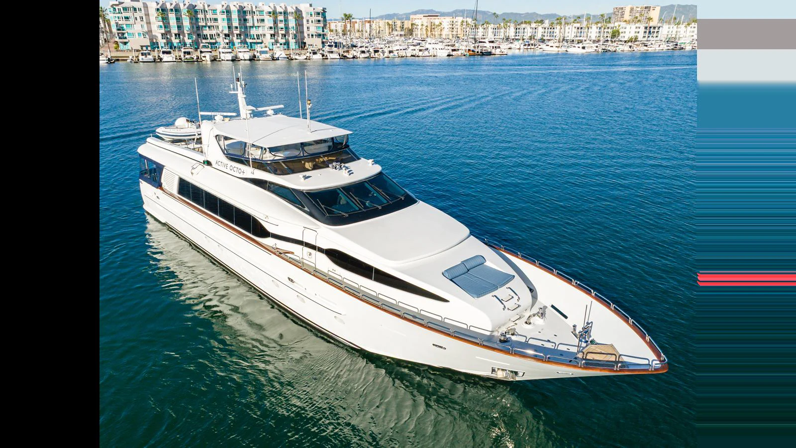 A sleek and modern yacht cruises gracefully on calm waters with a scenic marina in the background. aboard ACTIVE OCTO Yacht for Sale
