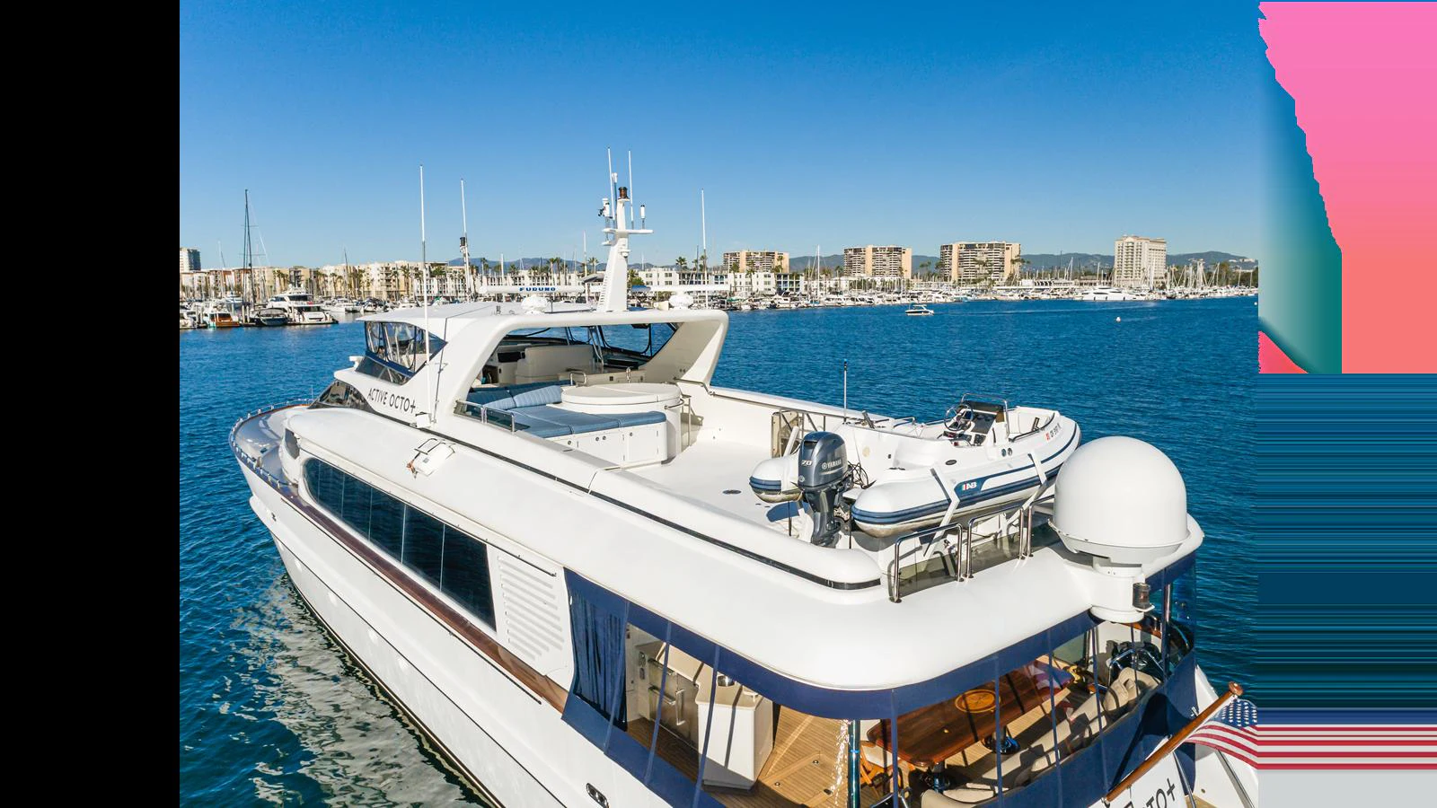 A sleek yacht with a spacious aft deck cruising in a vibrant marina. aboard ACTIVE OCTO Yacht for Sale