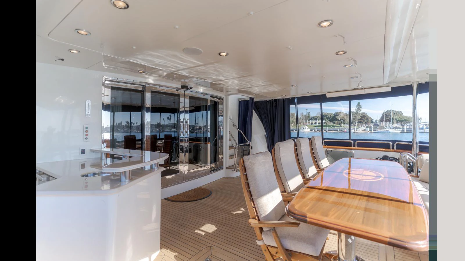 The aft deck features a spacious dining area with a polished wooden table and comfortable seating, perfect for enjoying meals with a view. aboard ACTIVE OCTO Yacht for Sale