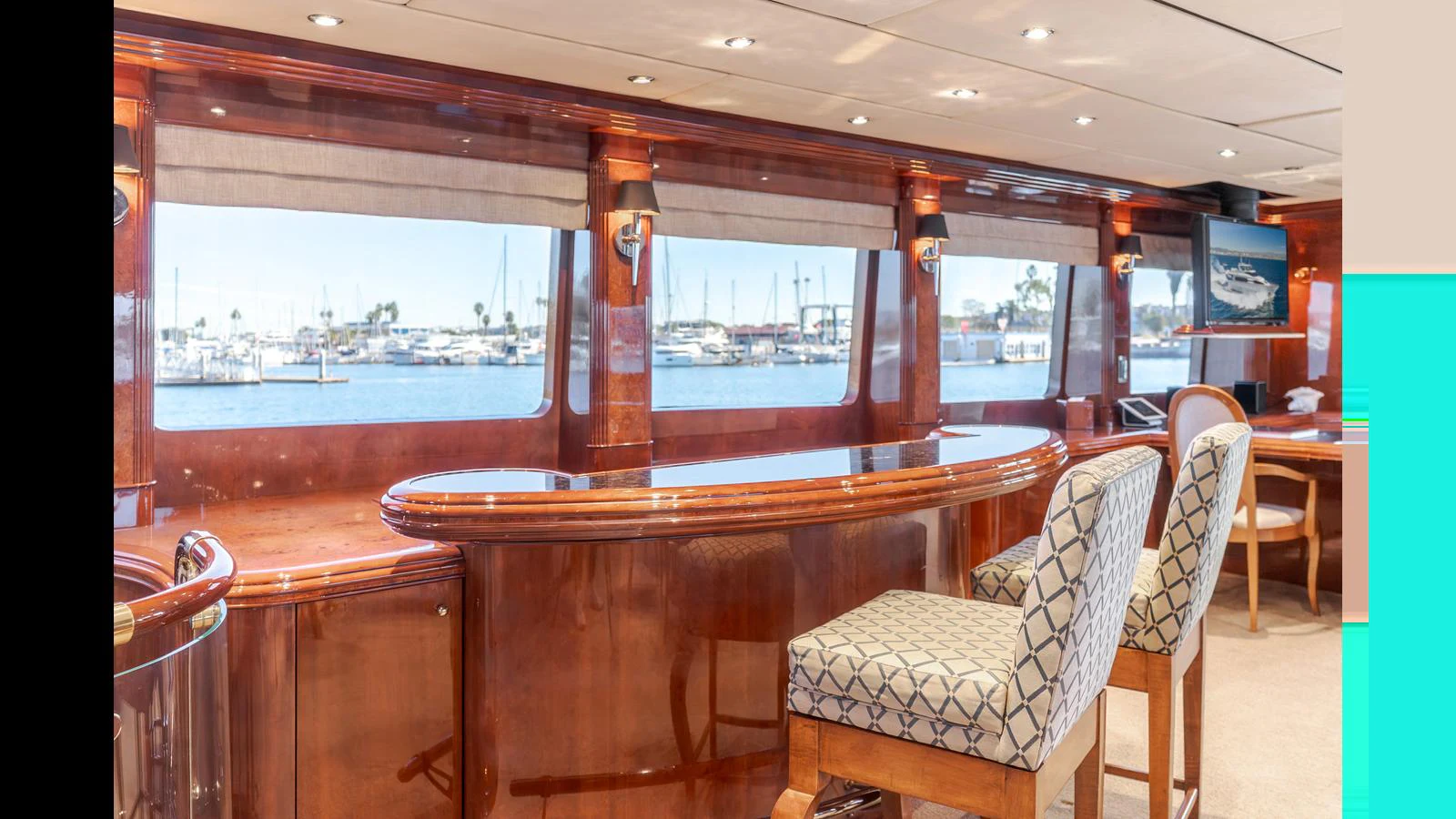 The saloon features elegant wood finishes and large windows offering a scenic marina view. aboard ACTIVE OCTO Yacht for Sale