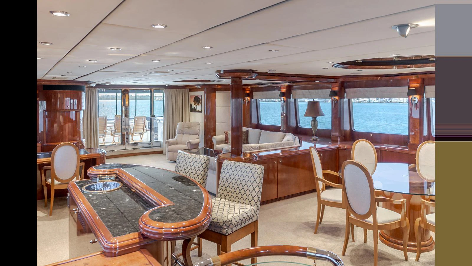 The yacht's salon features elegant seating, a dining area, and large windows offering stunning sea views. aboard ACTIVE OCTO Yacht for Sale