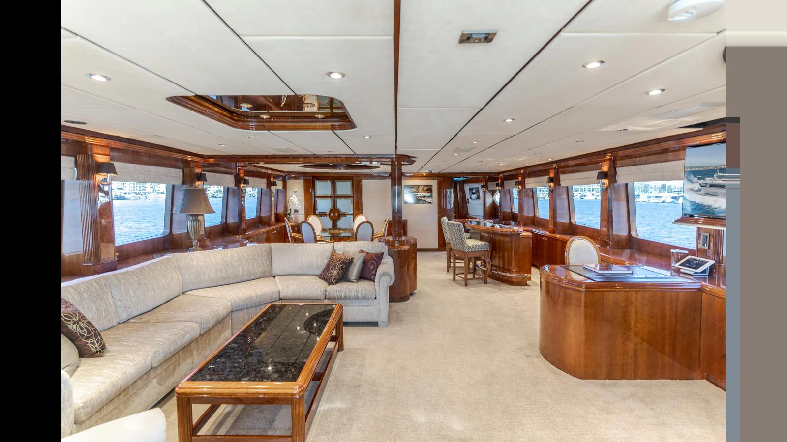 The spacious salon features elegant wood finishes and ample seating with panoramic windows offering stunning views. aboard ACTIVE OCTO Yacht for Sale