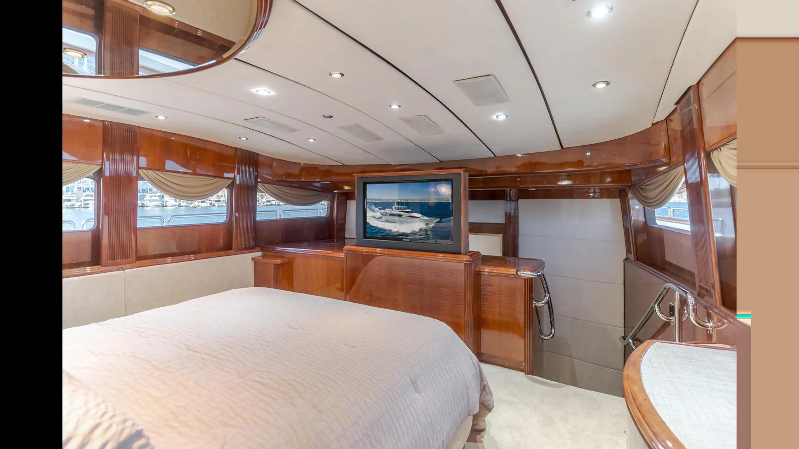 The master stateroom features a luxurious bed, elegant wood paneling, and a flat-screen TV. aboard ACTIVE OCTO Yacht for Sale