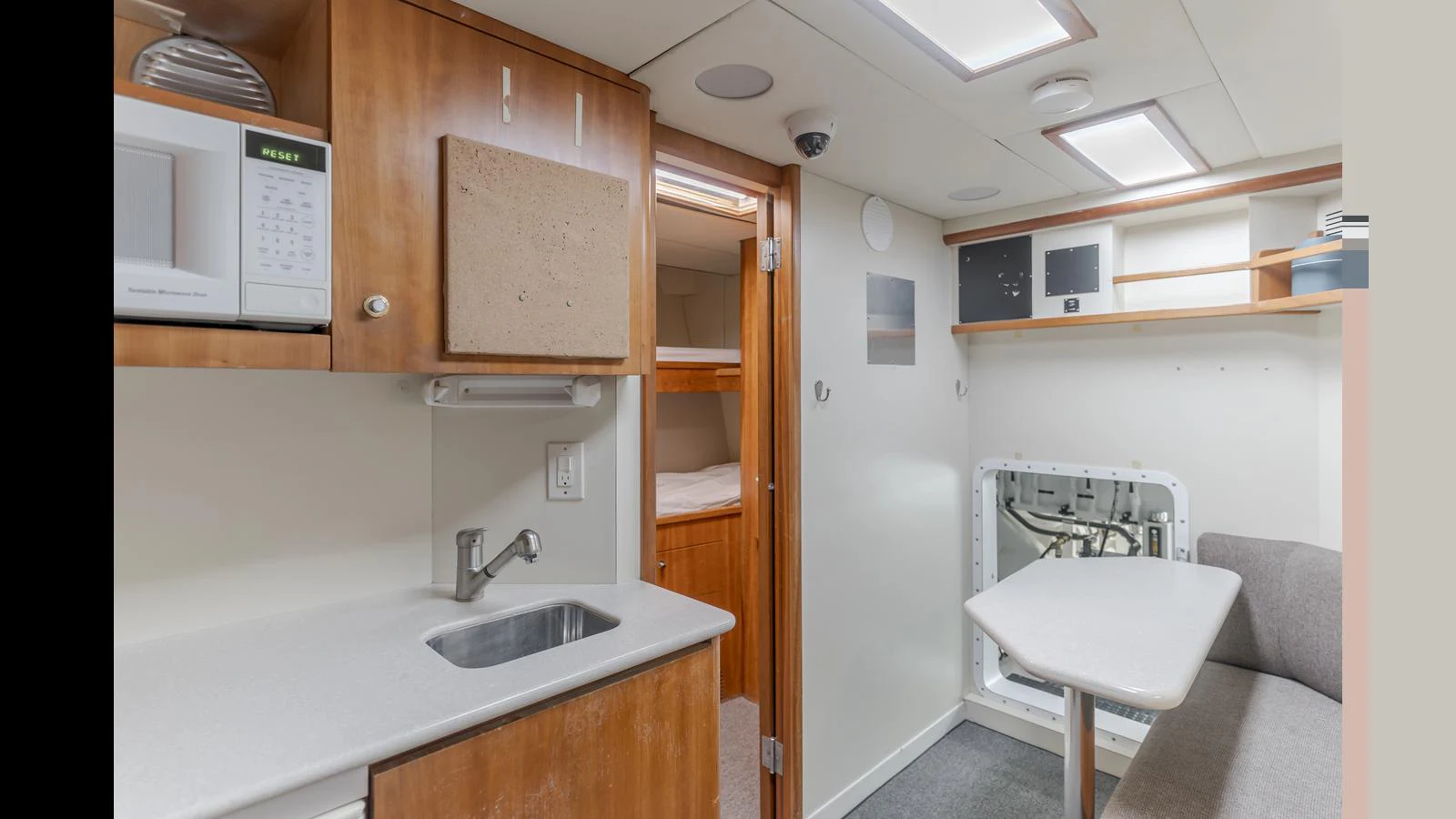 The yacht's interior features a compact galley area with a sink, microwave, and a small dining nook. aboard ACTIVE OCTO Yacht for Sale