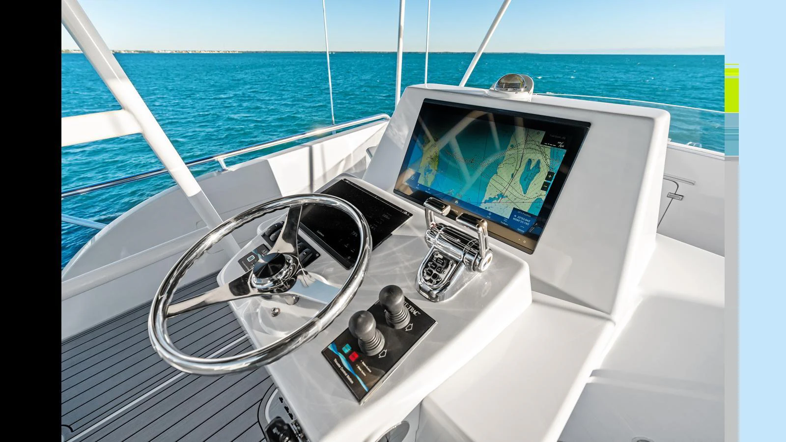 The helm station features state-of-the-art navigation equipment and a sleek steering wheel with a stunning ocean view. aboard FIRTH'S CHASM Yacht for Sale