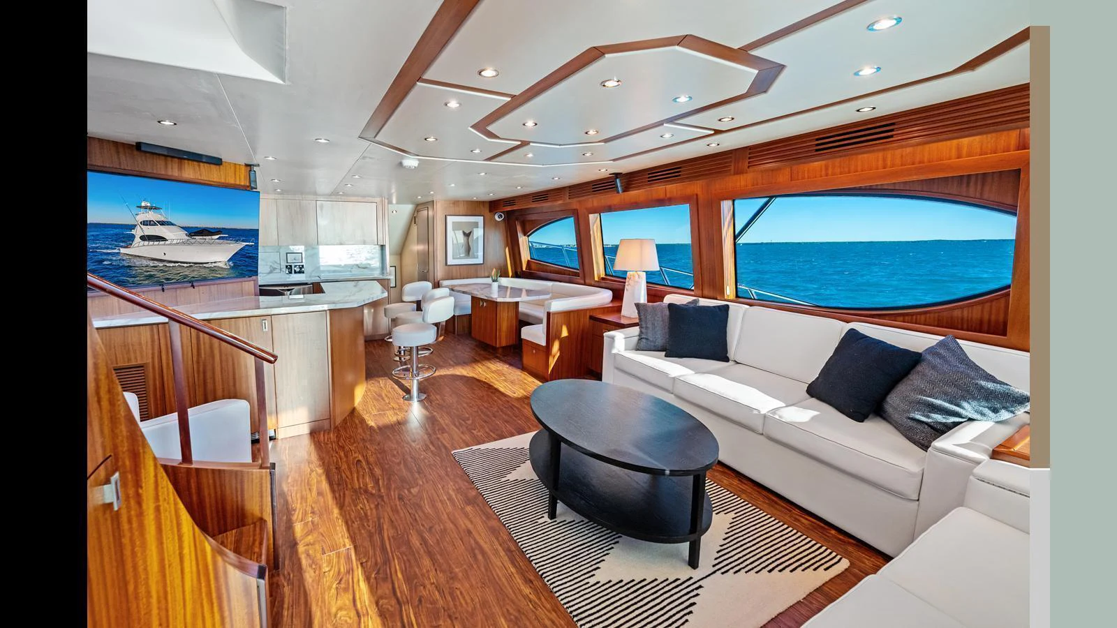 The salon features elegant wood paneling, plush seating, and expansive windows offering stunning ocean views. aboard FIRTH'S CHASM Yacht for Sale