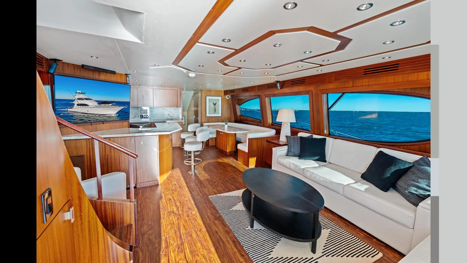 The salon features elegant wood finishes, a comfortable seating area, and large windows offering stunning ocean views. aboard FIRTH'S CHASM Yacht for Sale