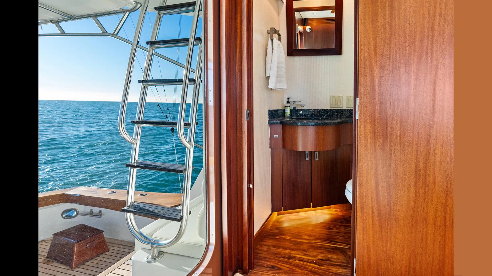 A glimpse into a yacht's bathroom with a view of the sea through the open door. aboard FIRTH'S CHASM Yacht for Sale