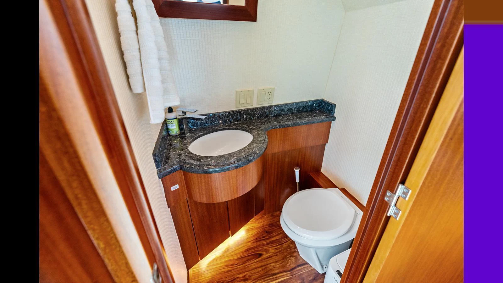 The yacht's head features a compact and stylish design with a granite countertop and wooden accents. aboard FIRTH'S CHASM Yacht for Sale