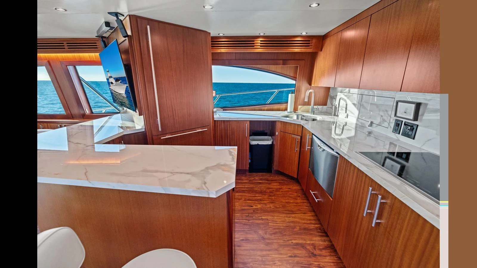 The yacht's galley features modern appliances and elegant wood cabinetry with a view of the sea. aboard FIRTH'S CHASM Yacht for Sale