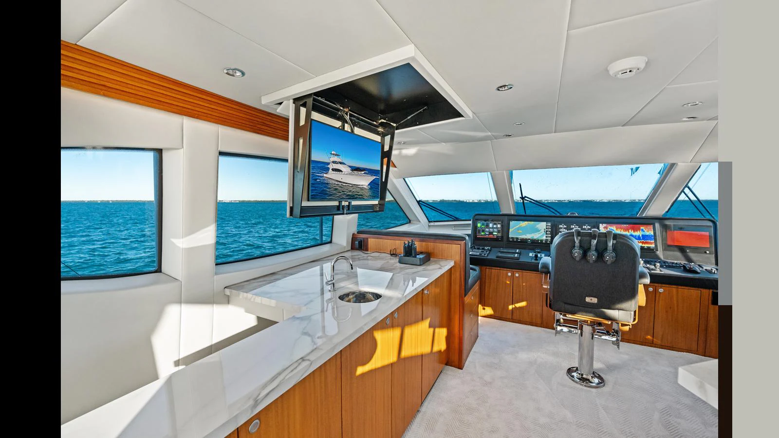 The helm area features a sleek design with modern navigation equipment and a comfortable captain's chair, offering panoramic views of the sea. aboard FIRTH'S CHASM Yacht for Sale
